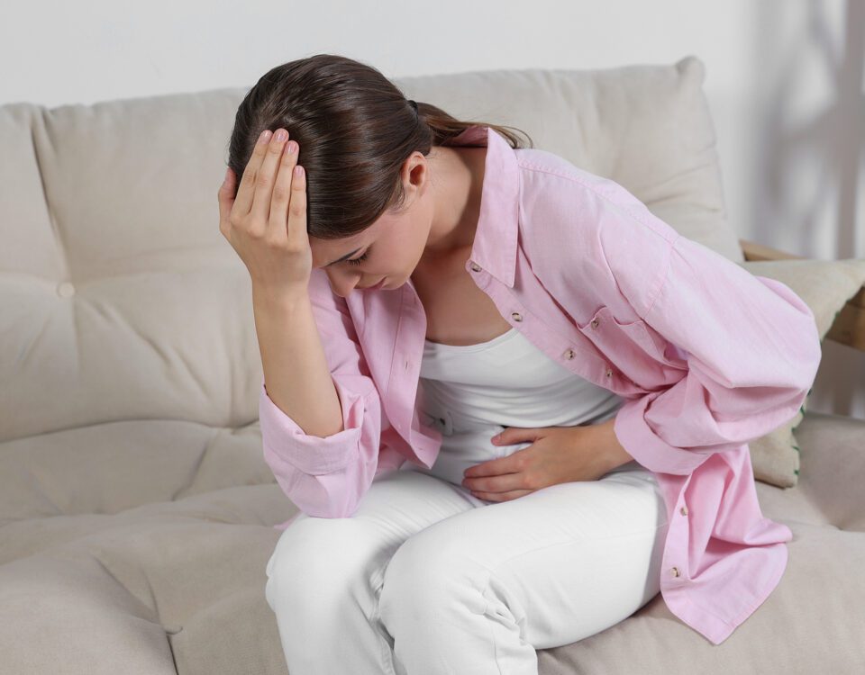 Young Woman Suffering From Cystitis On Sofa At Home