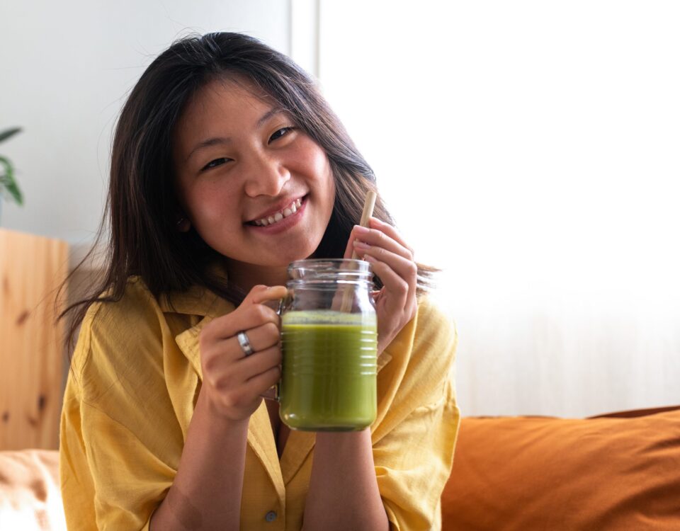 Happy Teen Asian Girl Showing Healthy Green Juice Looking At Cam